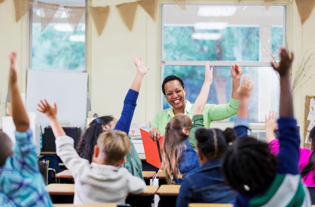 Students and teacher raising hands.