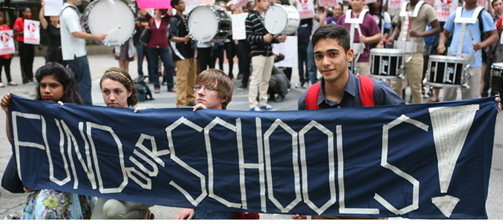 Students holding "Fund our Schools!" banner.