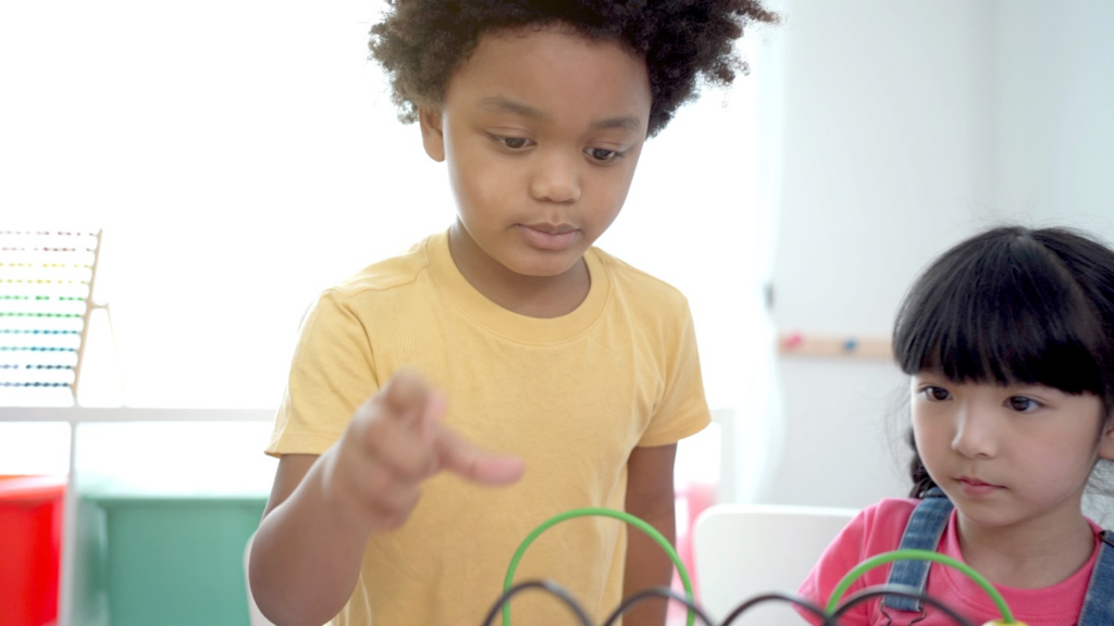 Young students playing with a learning toy.