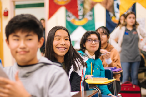 Students in classroom smiling.